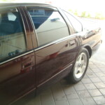 Before and after photographs of a damaged Chevy Impala that was repaired by Elite Paint & Body Shop in West Palm Beach, Florida.